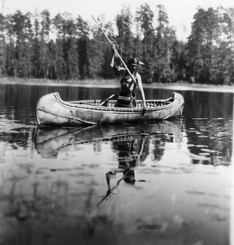 Ojibwe man fishing with a harpoon (Minnesota, 1908)