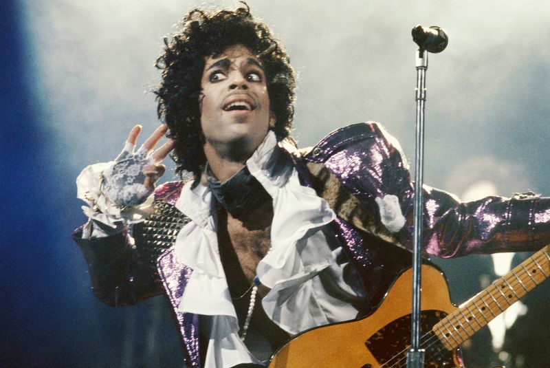 Prince – Purple Rain era, oozing charisma in ruffles and high heels.